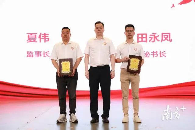 张国强为江门市爱促会第三届理事会监事长、秘书长颁发牌匾。受访者供图 图片