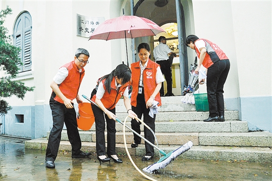 江门海关义工服务队队员正认真清扫地面。卢晓君