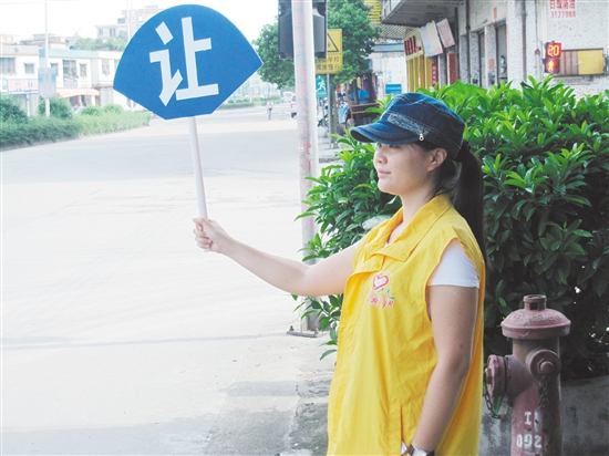 志愿者在红绿灯路口开展文明劝导志愿服务行动。