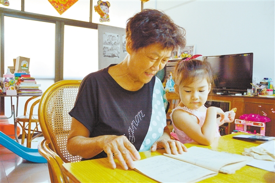 容颜锦拿出一本账单，回忆和婆婆相处的岁月，小孙女也在一旁看着。