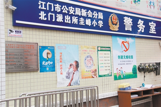 新会圭峰小学大门口张贴着“文明餐桌”行动海报。