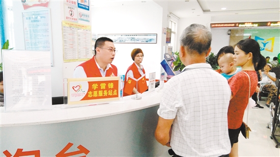 在白沙邑门式服务中心，学雷锋志愿服务站点的志愿者正和办事群众进行沟通。