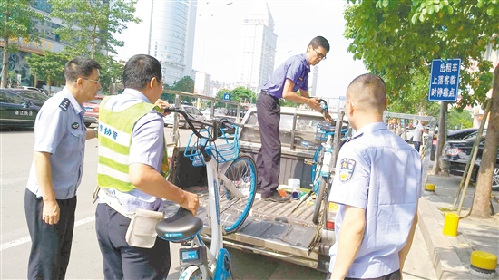 蓬江区联合执法大队对乱停放的共享单车作暂扣处理。 蓬江区联合执法大队对乱停放的共享单车作暂扣处理。